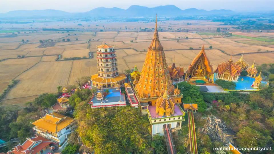 วัดถ้ำเสือ จุดเด่นของวัดบนยอดเขาแห่งนี้คือพระพุทธรูปสูง 18 เมตรที่ประดับด้วยกระเบื้องโมเสกสีทอง หนึ่งในพิธีทำบุญสำหรับผู้ศรัทธาคือการใส่เหรียญลงในถาดเล็กๆ บนสายพานลำเลียงที่หย่อนเงินบริจาคลงในชามตรงกลางพร้อมเสียงดังกังวาน การนั่งกระเช้าลอยฟ้าขึ้นไปบนยอดวัด (20 บาทต่อคน) ก็สนุกไปอีกแบบ แต่คุณสามารถเดินขึ้นบันไดก็ได้